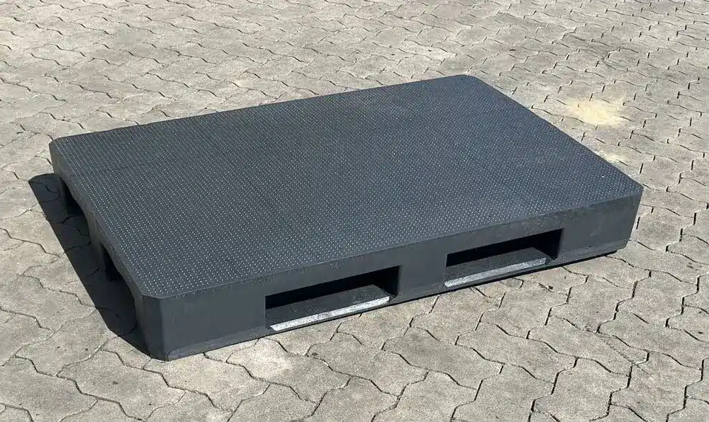Neue massive Europalette P18A aus anthrazitfarbenem Kunststoff mit Antirutsch-Noppen auf Pflasterboden